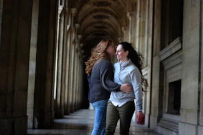 Adrianna and Lucas sharing a joyful laugh under a pastel-decorated archway.