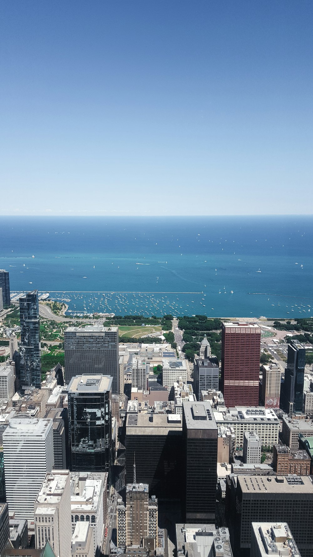 aerial photography of city with high-rise buildings near body of water under blue and white sky