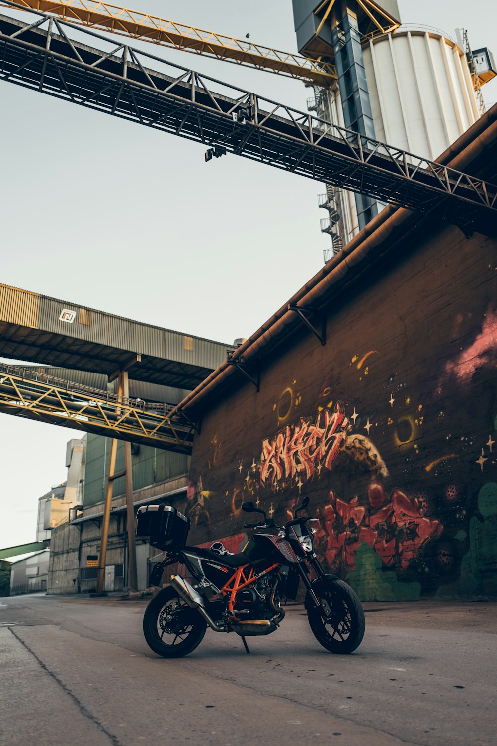 motorcycle parked near wall with murals