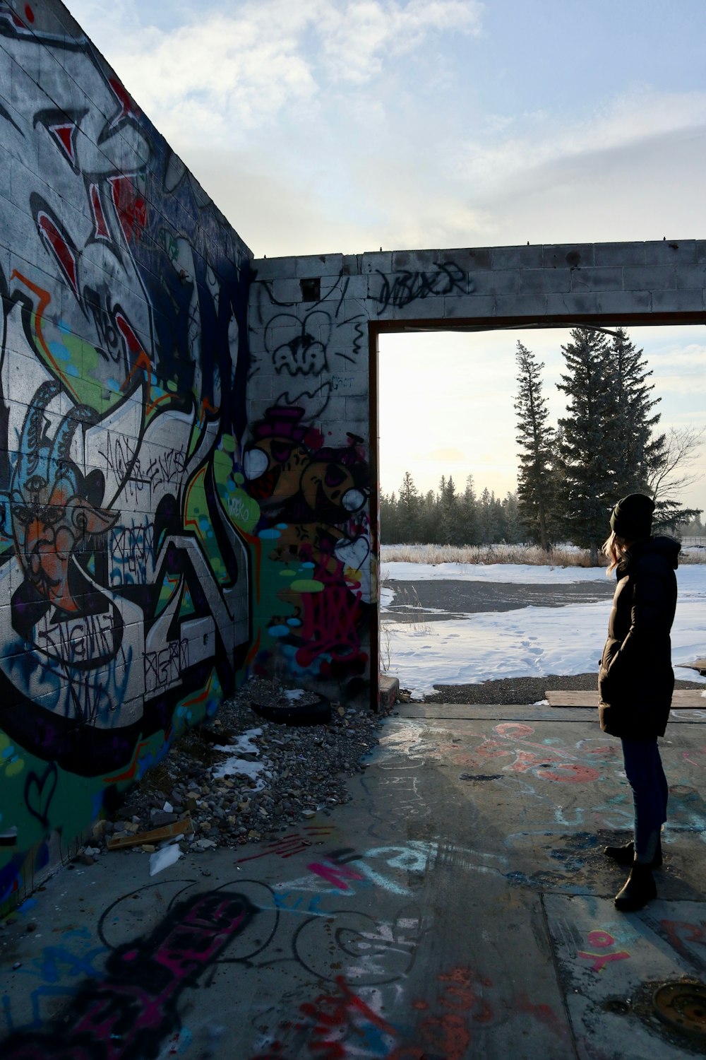 a woman standing in front of a graffiti covered wall