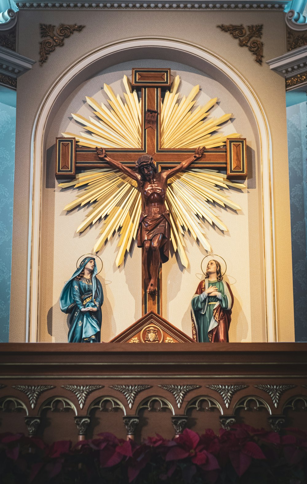 crucifix beside religious statues inside building