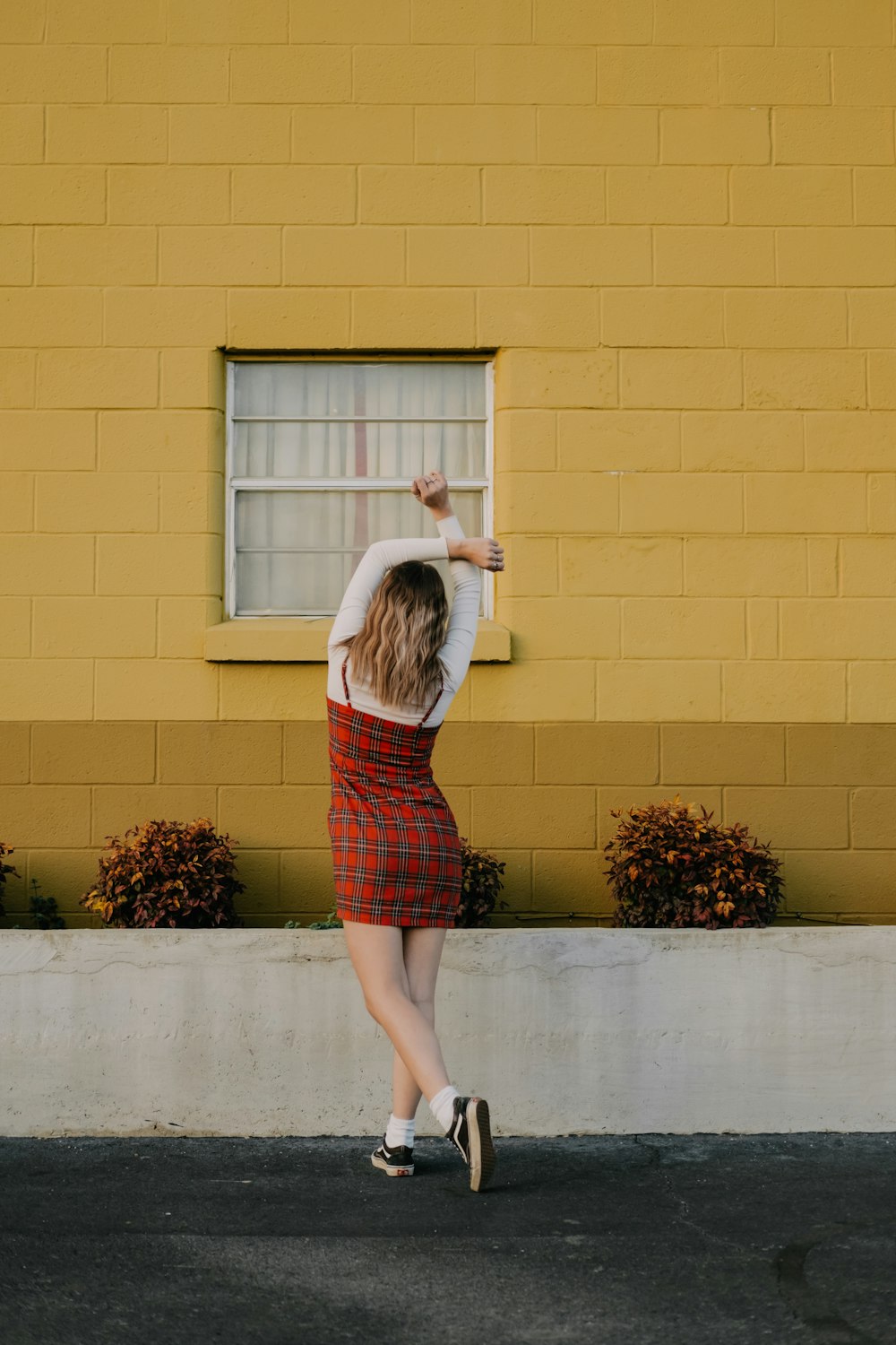 woman standing in front of building's window