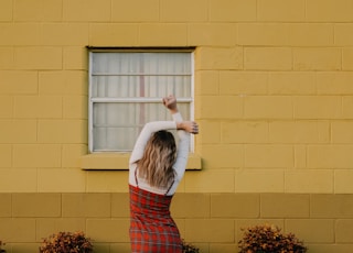 woman standing in front of building's window
