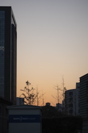 A minimalist, lightweight image showing a calm urban skyline of Noida Sector 76 during sunset.
