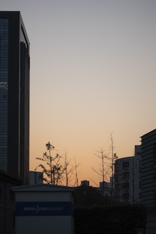 A minimalist, lightweight image showing a calm urban skyline of Noida Sector 76 during sunset.