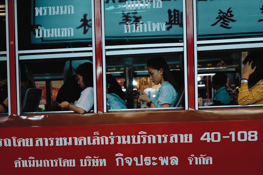 people sitting inside red bus