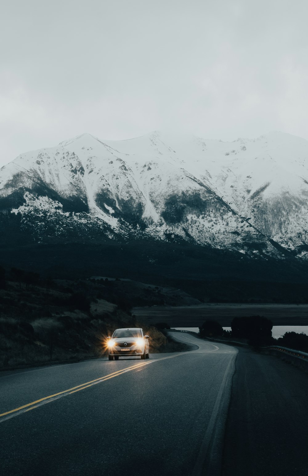 white vehicle on road viewing mountain covered with snow during daytime