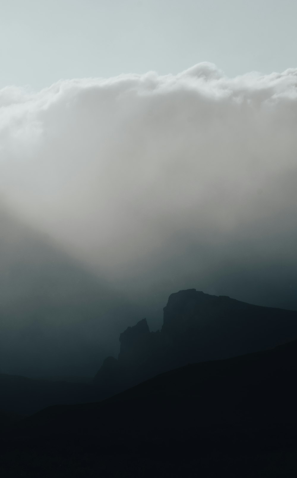 silhouette of mountain under cloudy sky