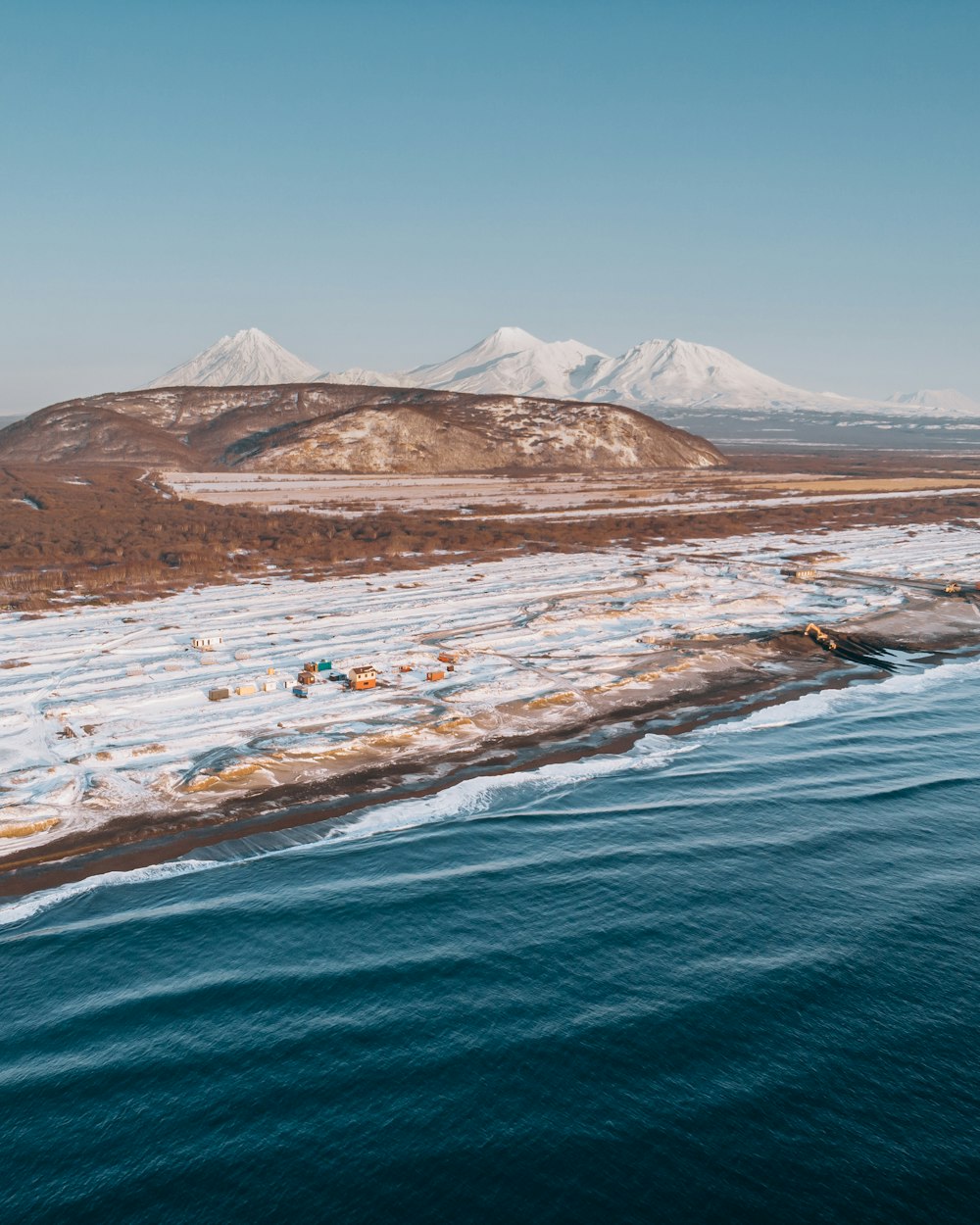 Campo de nieve y cuerpo de agua durante el día