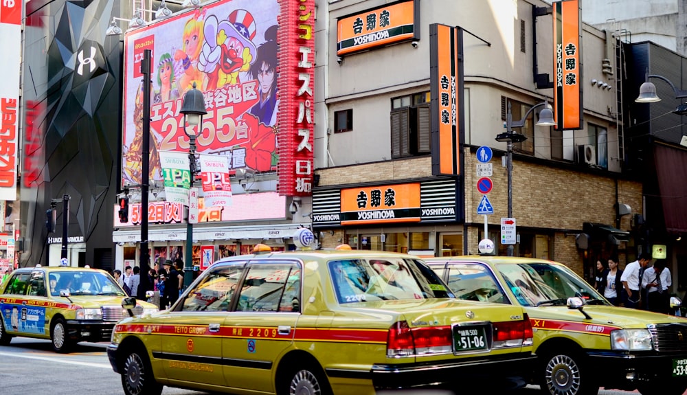 people walking on pathway near buildings and different vehicles on road during daytime