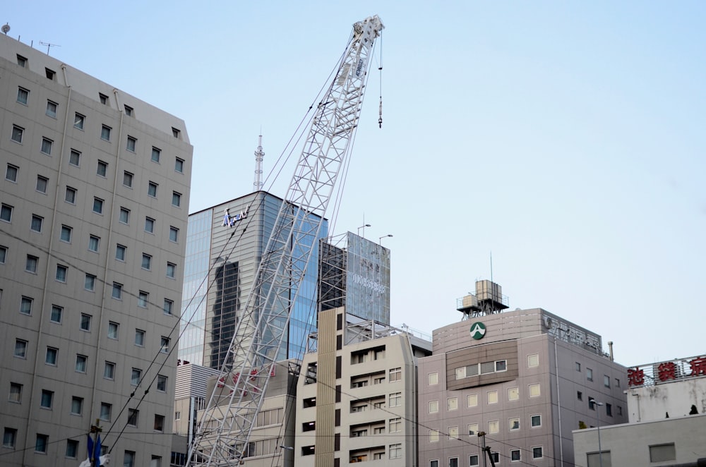 grey metal crane beside buildings during daytime