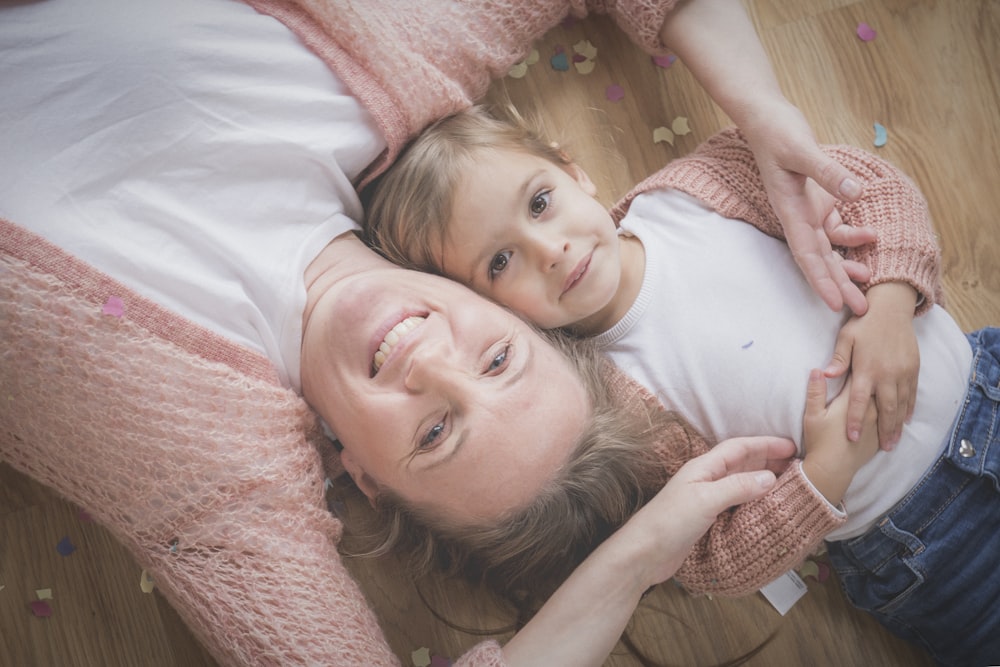 smiling woman lying beside boy