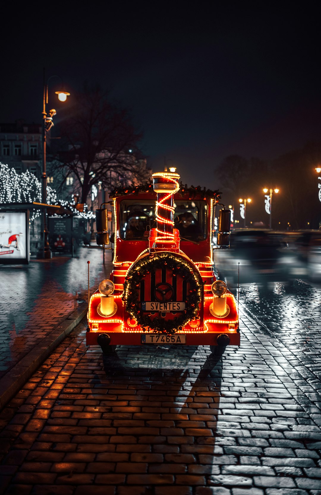 red and black train with lighted string lights during night time