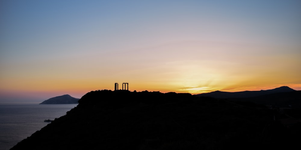 silhouette of people standing on hill during sunset