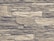 An arrangement of rectangular stones laid out in layers, forming a textured wall pattern. The stones vary in size and exhibit a rugged, rough appearance with natural lines and grooves.