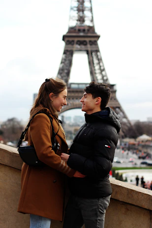 Smiling couple posing with the Eiffel Tower backdrop at Disneyland Paris.