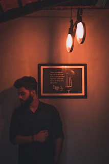 A dimly lit framed poem glowing softly with ember accents against a charcoal gray wall