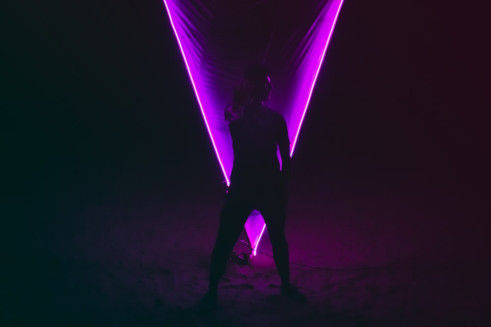 a person standing in front of a purple light