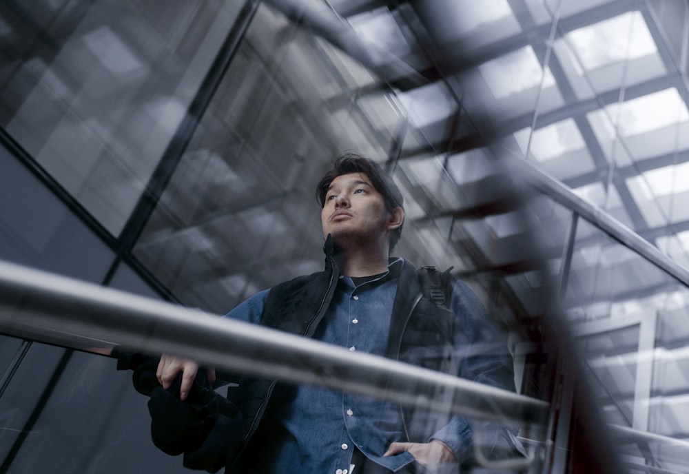 man beside railing indoors