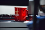 A stylish mug with the Lazy Legend Club logo on a desk.