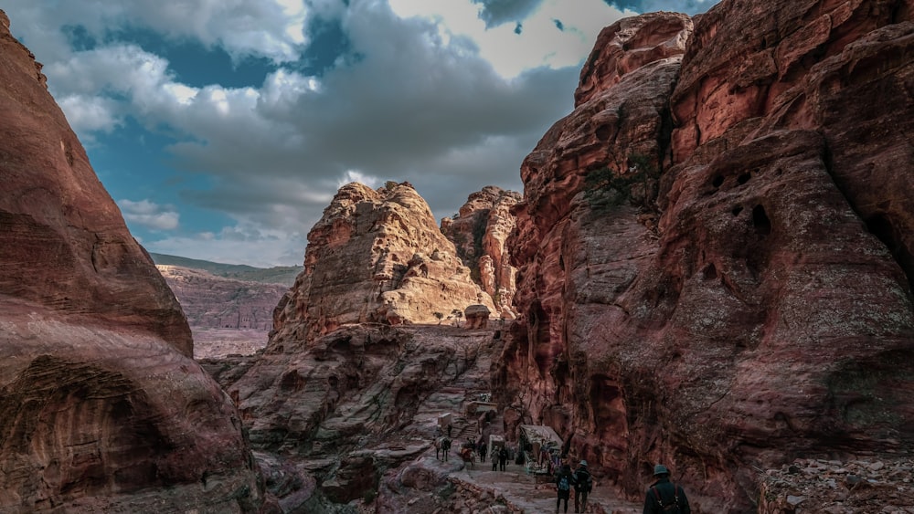 people standing near Grand Canyon under white and blue sky