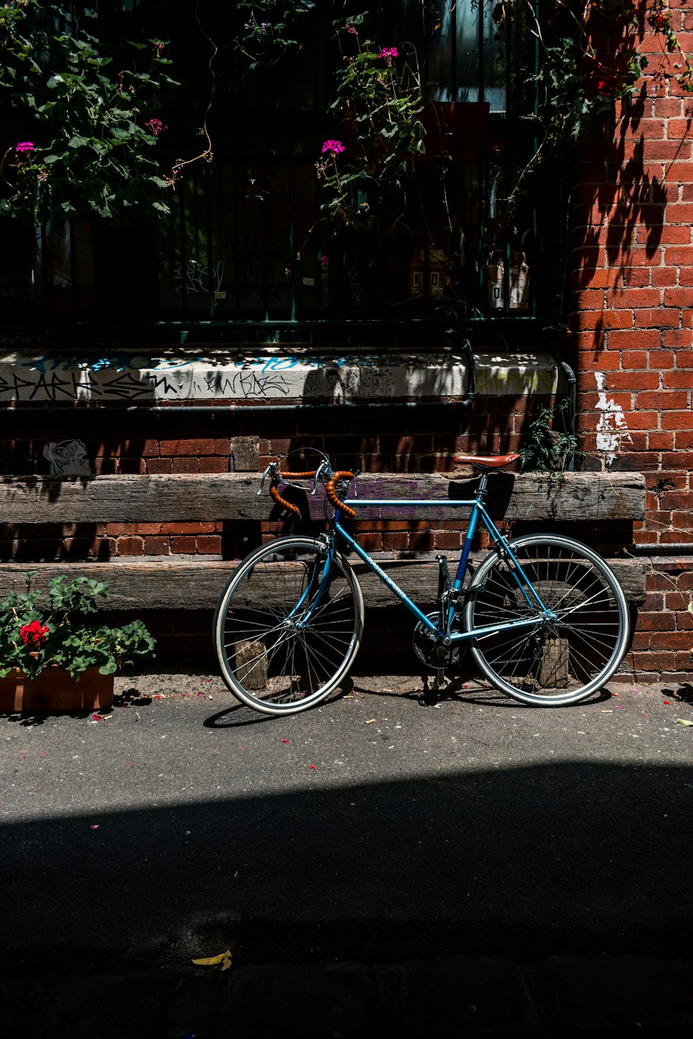 blue road bike parking near wooden fence