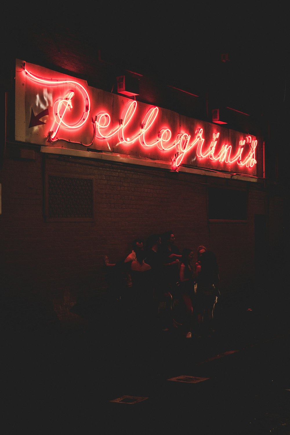 people standing outside Pe4llegrinis building during night time