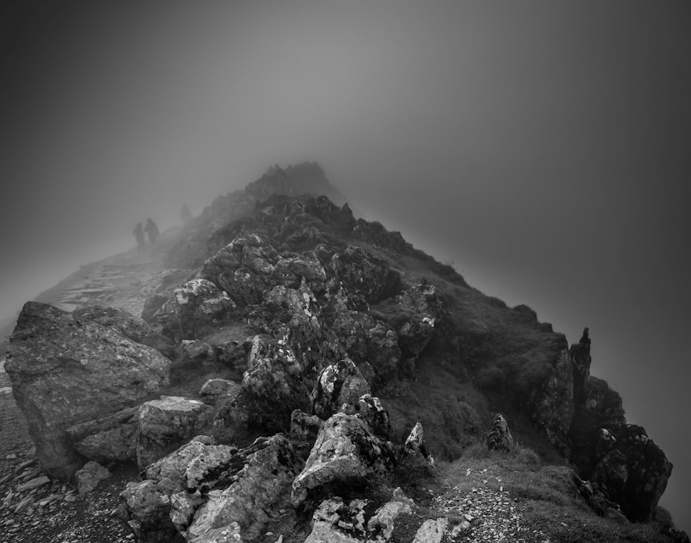 grayscale photography of mountain range in foggy day