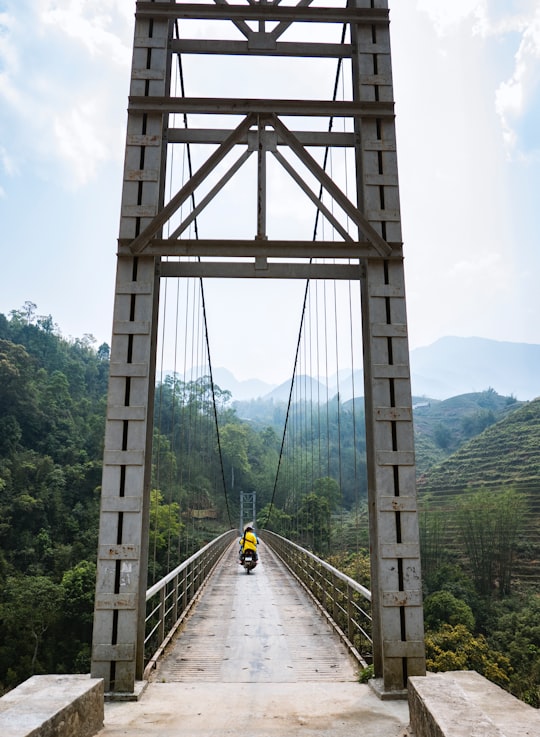 motorcycle passing on bridge during daytime in Sapa Vietnam