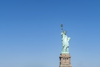 A symbolic statue representing justice and freedom under a clear sky.