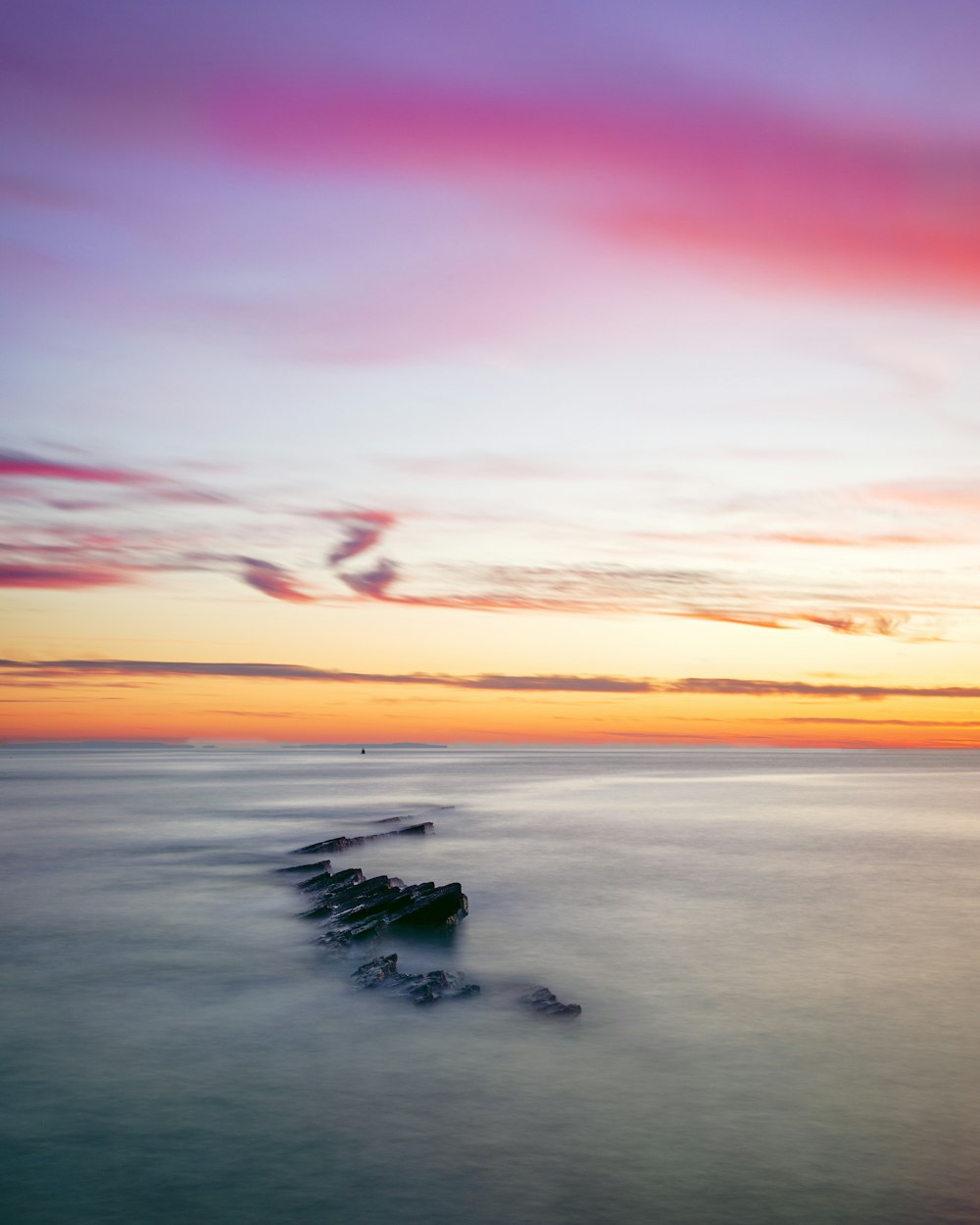 body of water under cloudy sky during golden hour