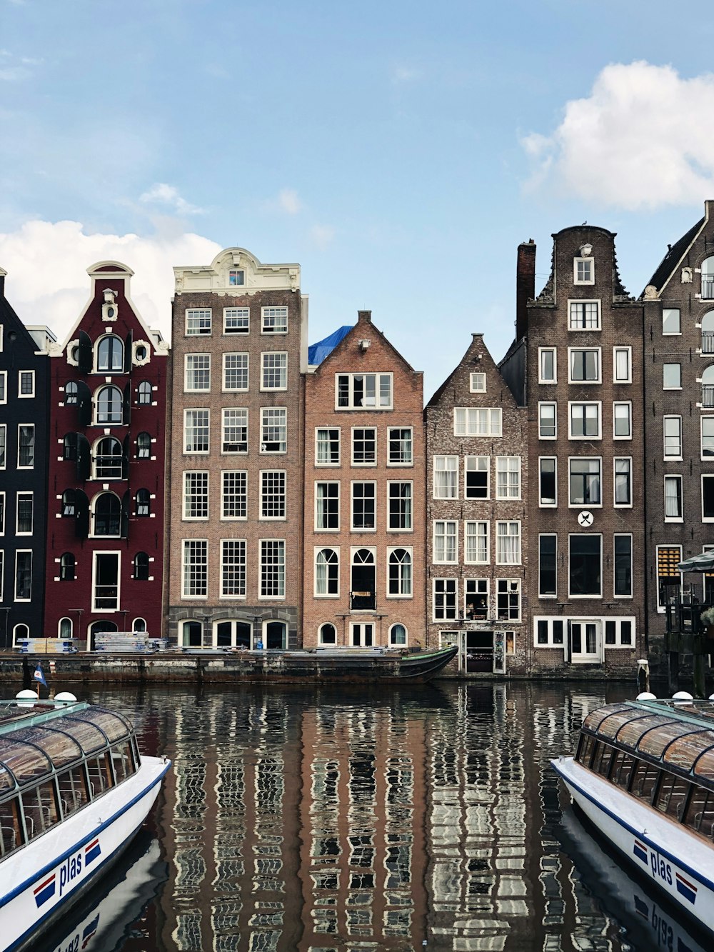 reflection of canal houses on body of water