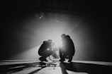 grayscale photography of two crouching men