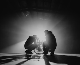 grayscale photography of two crouching men