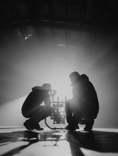 grayscale photography of two crouching men