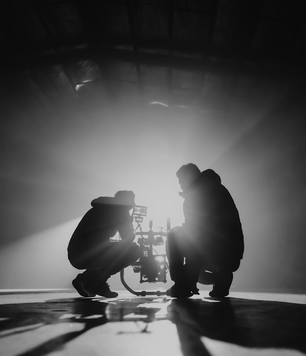 grayscale photography of two crouching men