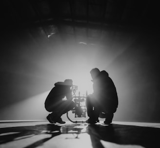 grayscale photography of two crouching men