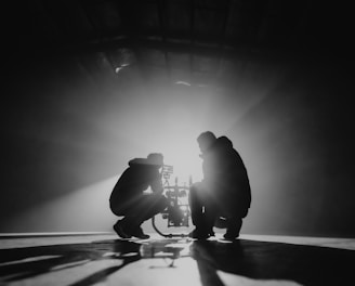 grayscale photography of two crouching men