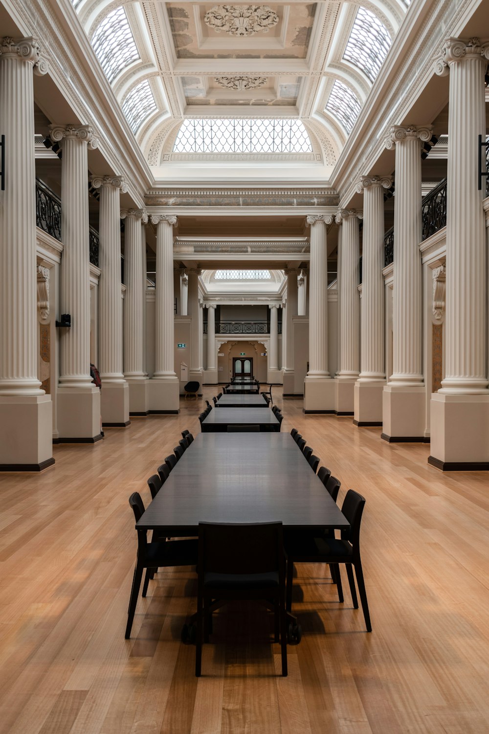 empty black chairs and tables inside white pillared building