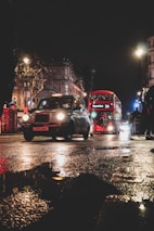 vehicle in front of red double-decker bus at night