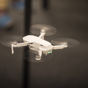 selective focus photography of flying white drone copter