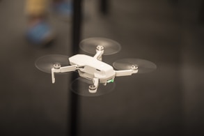 selective focus photography of flying white drone copter