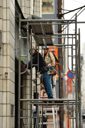 two men standing on scaffolding