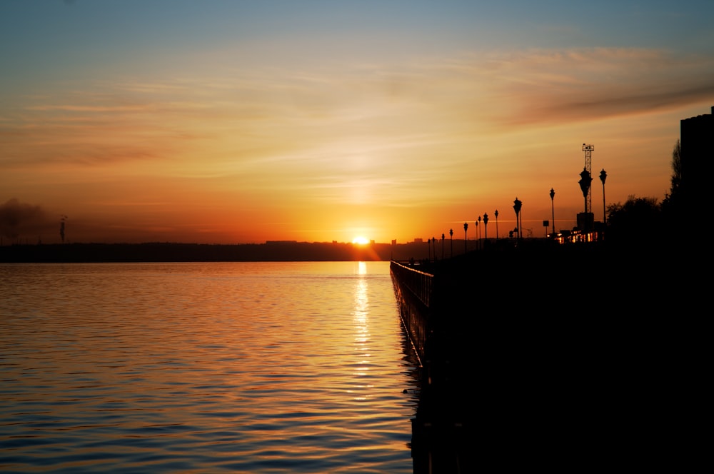 the sun is setting over a body of water