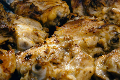 Close-up photo of sizzling chicken döner on the open flame, showing juicy texture and vibrant colors.