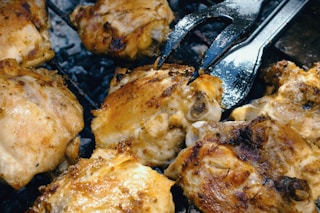 BBQ, grill, kebab. Skinless chicken with fried onions on a grill. Close-up.	