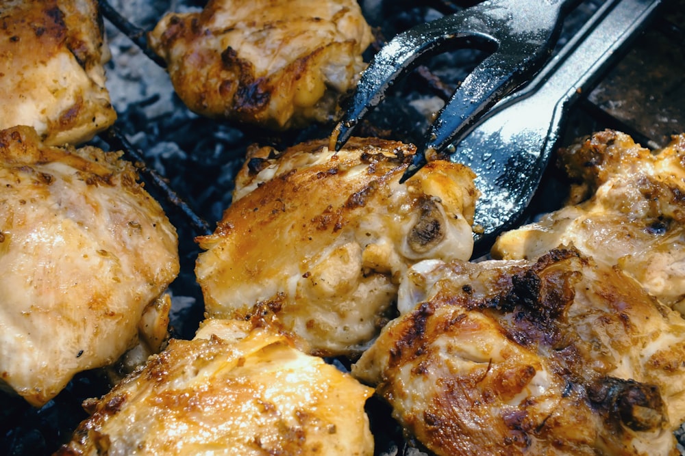 Un primer plano de pollo en una parrilla con un tenedor