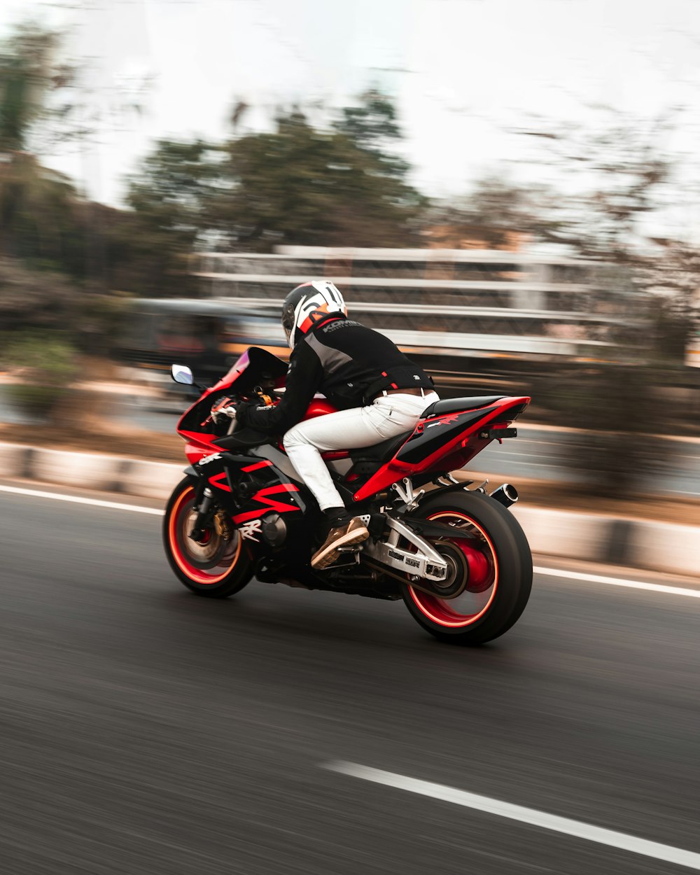 man riding red sports bike