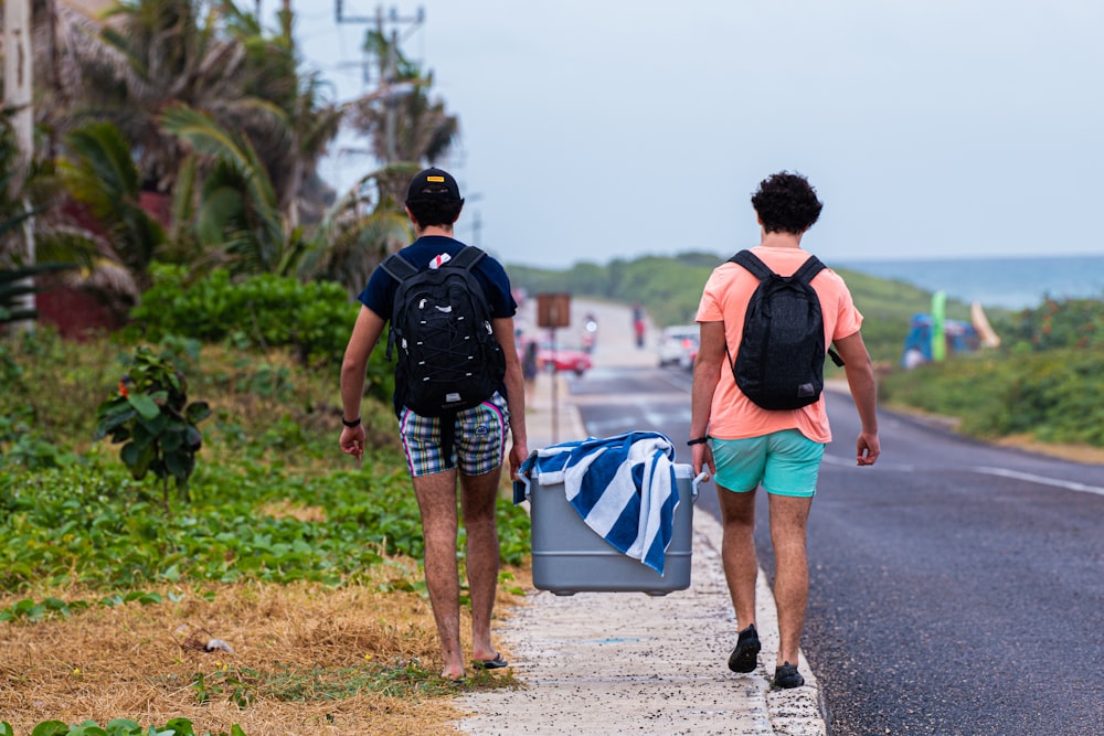 two men carrying ice cooler box