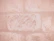 Close-up of a hand smoothing out a textured wallpaper on a bedroom wall.